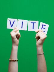 Mot VITE en carton et bois tenue par une main d'enfant sur fond vert détourage facile pour...