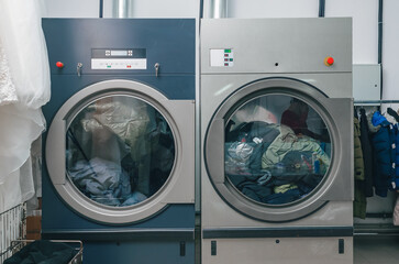Front view of dry cleaning dryer. The dry cleaners have two dryers loaded with clothes.