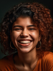 Young woman with curly hair smiling on a black background.