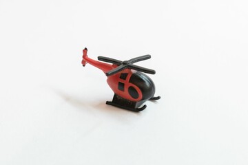 Closeup of a red helicopter miniature isolated on white surface