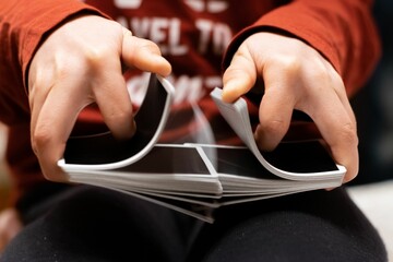 Closeup of person's hands shuffling the card deck on the table