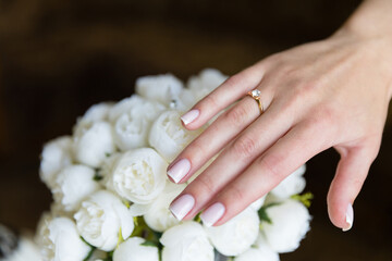 Obraz na płótnie Canvas Brush with engagement ring on the background of a beautiful bouquet of white flowers