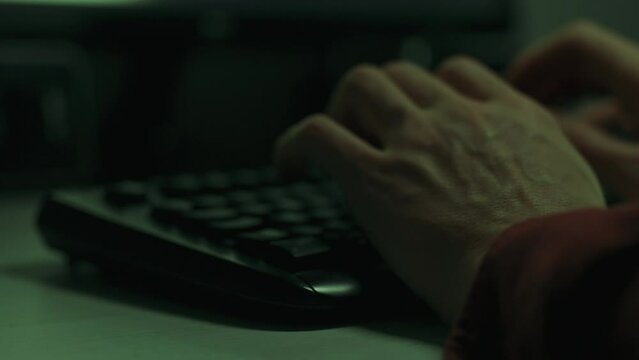 The hands of an IT specialist work at a laptop, typing code. Close-up of a man's hands on a computer keyboard typing text. Working on a laptop computer. Remote work distance learning concept