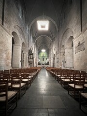 empty cathedral with rows of wooden chairs and chandeliers