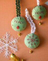 Closeup of beaded Christmas tree decorations on an orange surface - obrazy, fototapety, plakaty