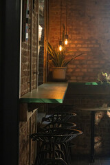 Contemporary bar setting with a row of chairs and a brick wall in the background