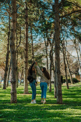 Obraz premium A full length photo of two lovely girls having fun in the park, on a beautiful sunny day