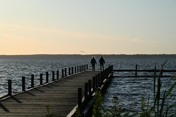 Silhouetted figures on the wooden dock on a windy day