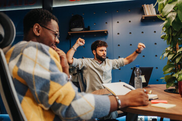 Naklejka premium Diverse entrepreneurs collaborate in a small office, using technology to drive growth.