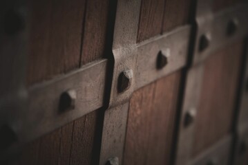 Close-up of a brown wooden wall with visible rust-covered bolts