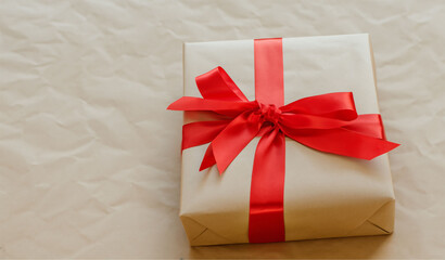 Christmas Present with Brown Wrapping and Red Box on Brown Paper