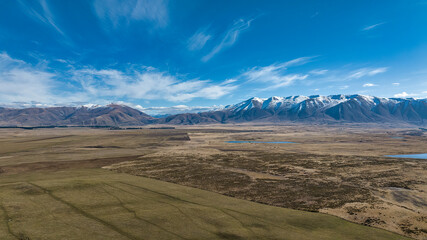 The way to Lake Ohau and the southern alps through alpine grasses and tundra terrain