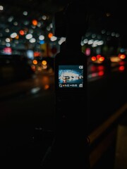Close-up of a digital camera display illuminated in the night, showing several cars parked in a lot