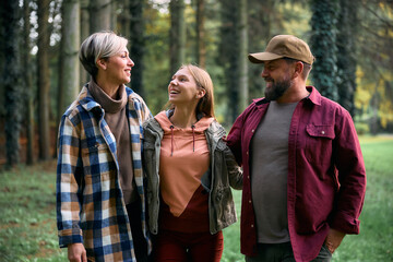 Happy family talking while spending a day in forest.