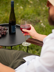 A man is holding a glass of red wine