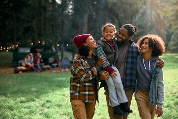 Happy black family enjoys in camping day in woods.