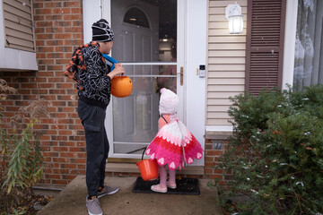 Brother with Autism and younger sister with 10 year age gap trick or treat together; boy dressed as...