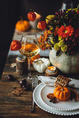 Fall table decoration with pumpkins, wine. Family cozy thanksgiving dinner arrangement indoors at...