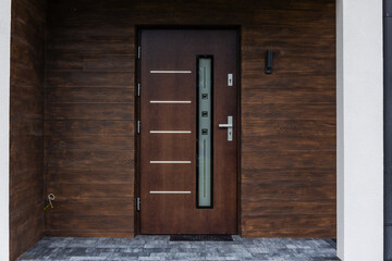 Designer entrance door to a country house. Modern design. luxurious exterior. Facade of a modern building with modern doors.