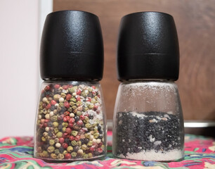 Salt and pepper from different prospective in glass bottles 