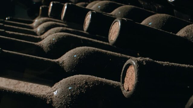 Tracking Close Shot of Old Aged Stacked Wine Bottles in a Cellar