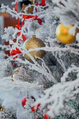 Close-up of decorations and lights on a snowy Christmas tree. High quality photo