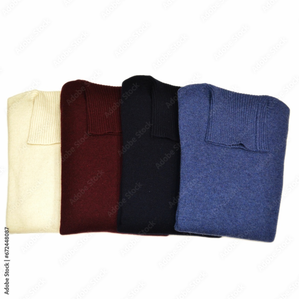 Wall mural folded high-neck wool sweaters of different colors on a white background