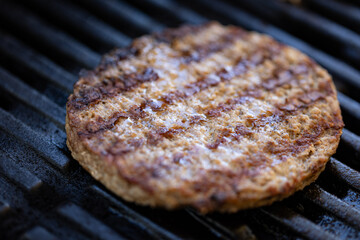 Close up of a burger on barbecue grate