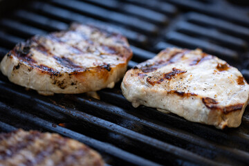 Two freshly grilled small pork fillets placed on cast iron bbq grates