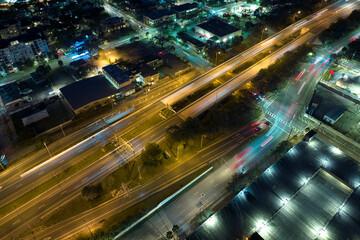 Fototapeta na wymiar Above view of wide highway crossroads in Tampa, Florida at night with fast driving cars. USA transportation infrastructure concept