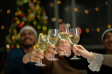 close up glasses of clinking glasses of champagne with lighting. Party of asian friend female and male celebrating. happiness friends christmas eve celebrate dinner party with food and champagne.