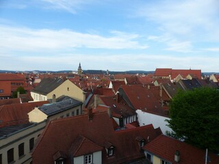 an overhead view shows the skyline of red roofs on buildings