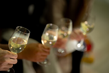 close up glasses of clinking glasses of champagne with lighting. Party of asian friend female and male celebrating. happiness friends christmas eve celebrate dinner party with food and champagne.