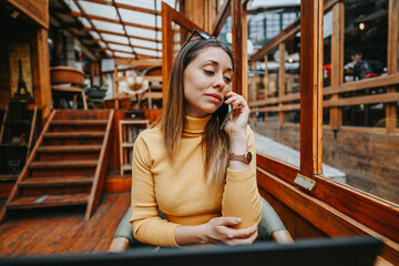 Multicultural startup team brainstorms product development, collaborates with angel investors for financial planning, and strategizes growth for profitability and scalability at an urban coffee bar.