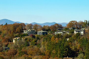 Naklejka premium Aerial view of expensive american homes on hilltop in North Carolina mountains residential area. New family houses as example of real estate development in USA suburbs
