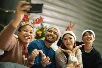 Party of asian Friends Enjoying Christmas Drinks and celebrating having selfie by smartphone....