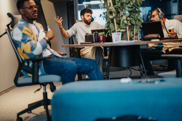 Focused employees working at a modern co-working space, browsing the internet for market research. Successful entrepreneurs targeting their audience and driving profit growth through online work.