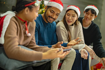 Fototapeta premium Party of asian Friends Enjoying Christmas Drinks and celebrating having selfie by smartphone. happiness women and man christmas eve celebrate dinner with food and beverage.