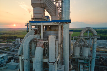 Cement plant with high factory structure and tower cranes at industrial production area....