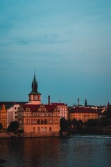 Fototapeta premium Majestic building set atop a hill overlooking a tranquil river in Praha, Czech Republic
