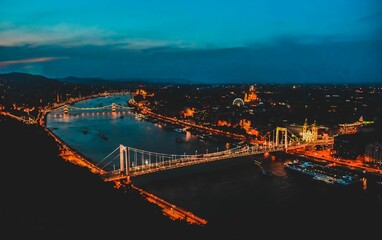 Aerial view of Budapest cityscape with a bridge spanning a river in the city during a golden sunset