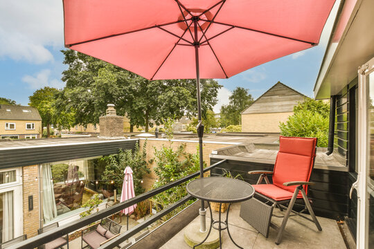 Red chair with table and parasol in balcony