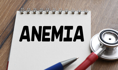 ANEMIA word in a notebook next to a stethoscope.