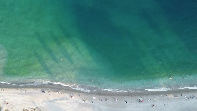 Sommer am Strand im Mittelmeer mit Touristen und leichtem Wellengang durch Luftaufnahmen mit Drohne