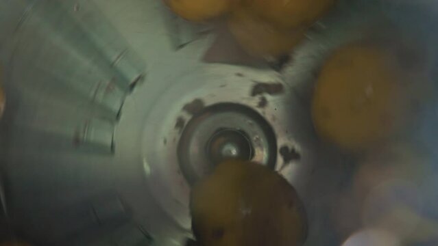 Raw yellow potatoes being cleaned and tossed around in an industrial washing machine. Closeup shot. Food and hygiene concept. High quality 4k footage