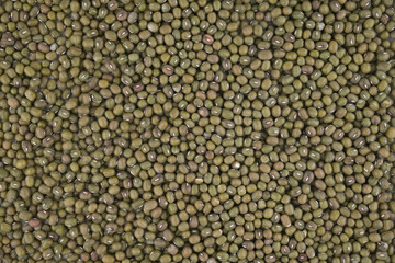 Crop of many dry green lentil grains on flat surface as background