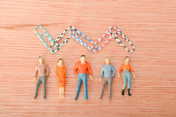 A group of people standing together, with paper clips serving as a symbol of unity and teamwork.