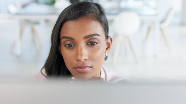 Trendy young editor proof reading an article and thinking about the content and information to be posted on her blog. Female blogger working to complete a publication on a computer in her office