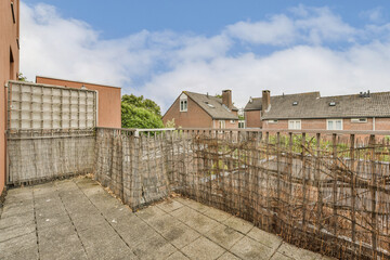 Fototapeta premium an outside area with fences and houses in the background on a cloudy day, as seen from behind it