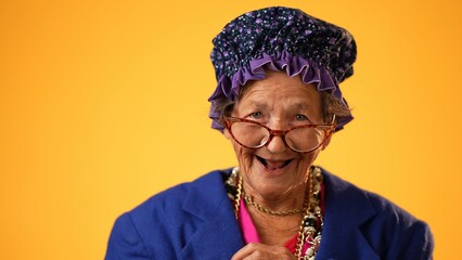 Closeup of funny happy smiling crazy grandmother mature woman, 80s, 90s, isolated on yellow...